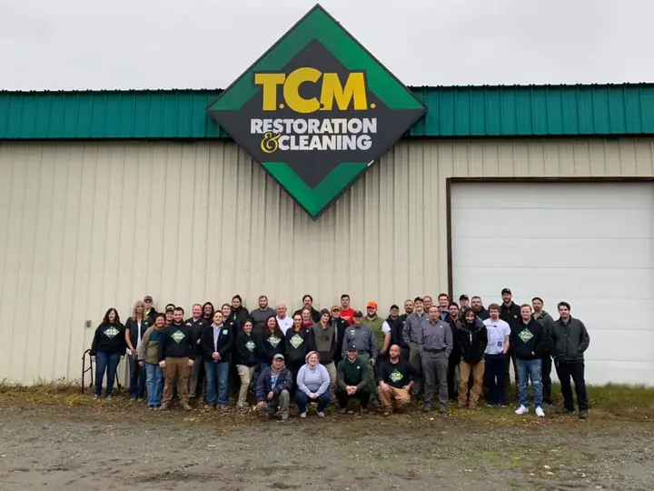 The TCM Restoration team gathered in front of the company facility